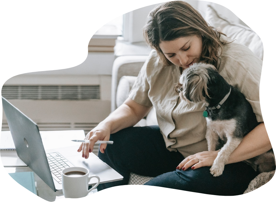 Une femme et un chien devant un ordinateur portable